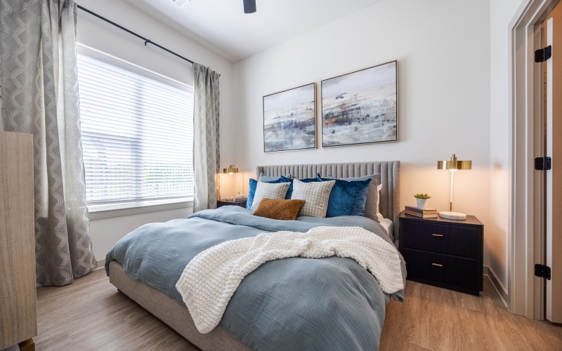 a bedroom with large windows and contemporary furnishings